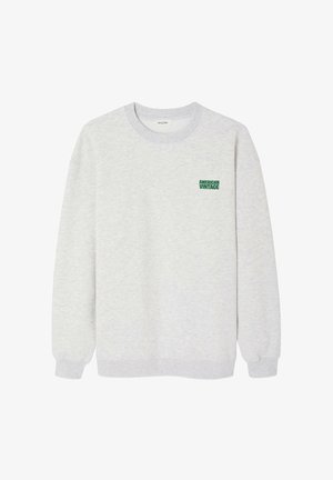 Harmaa collegepaita, joka on valmistettu pehmeästä kankaasta ja jossa on ribbineuleinen kaula-aukko ja hihansuut. Rintataskussa on vihreä "AMERICAN VINTAGE" -logo.