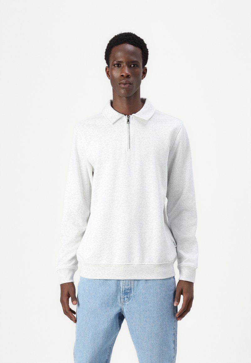 Lichtgrijze ritshoodie met een kraag, lange mouwen, ribgebreide manchetten en een rechte zoom, gecombineerd met lichtblauwe jeans.