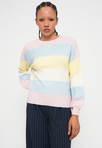Maglione a righe in colori pastello: rosa, azzurro, giallo e bianco. Texture morbida, scollo rotondo e vestibilità comoda. Maniche lunghe e polsini a costine.