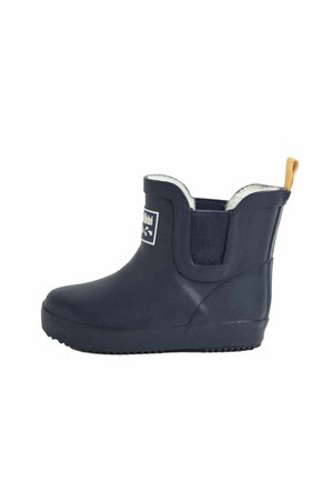 Botte en caoutchouc marine montant jusqu'à la cheville avec panneau latéral élastique, doublure en fausse fourrure blanche, et tirette beige au talon. Semelle texturée pour une meilleure adhérence et stabilité.
