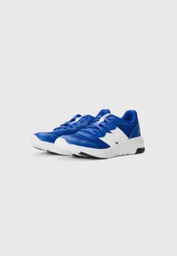 Baskets de sport bleues avec une tige en mesh, accents blancs, bout rond et semelle texturée. Lacets et conception légère pour le confort.
