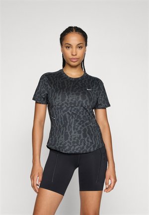 Schwarzes Sport-T-Shirt mit einem Leopardenmuster in verschiedenen Grautönen. Kurze Ärmel, runder Ausschnitt und dezente Logo-Details.