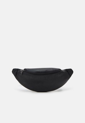 Czarna torebka na pas w kształcie półksiężyca z subtelnymi, tłoczonymi logo oraz górnym zamkiem błyskawicznym na jednolitym jasnym tle.