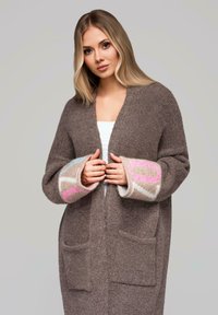 Cardigan marrone in lana con scollo a V, caratterizzato da polsini decorati con motivi in rosa, blu e beige. Include due tasche frontali. Vestibilità classica e rilassata.