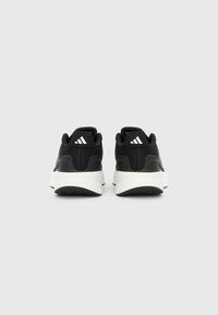 Juodi sportiniai batai su tekstūruotu viršumi, baltu viduriniu padažu ir prekės ženklo kulno akcentais su trimis juostelėmis.