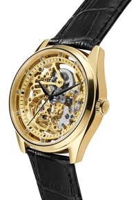 Skeletor klokke med gullfarget kasse, som har intrikate gull- og sølvmekaniske komponenter, svart lærrem og svarte visere.