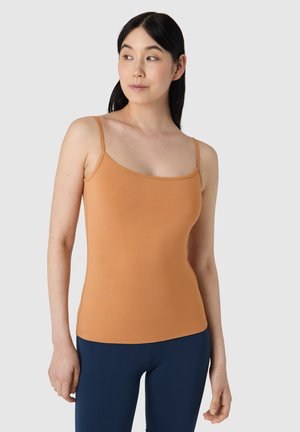 Oranje tanktop met dunne bandjes, gemaakt van rekbare stof. Gladde textuur, aansluitend ontwerp, met een ronde halslijn. Draag met marineblauwe leggings.