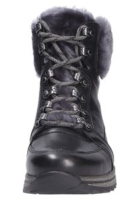 Bottes en cuir noir avec bord en fausse fourrure grise, œillets métalliques et lacets scintillants. Tige texturée et semelle robuste conçue pour les conditions hivernales.