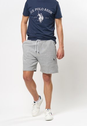 Gray cotton shorts with an elastic waistband and drawstring. Paired with a navy T-shirt featuring white U.S. Polo Assn. logo and graphics.