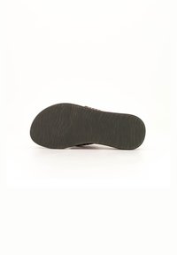 Sandal outsole featuring a wavy texture, dark color, and contoured shape, designed for grip and comfort in various environments.