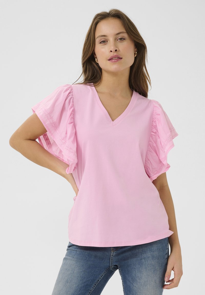 Roza bluzica s V-izrezom in nabranimi kratkimi rokavi. Narejena iz mehkega materiala, s kompleksnimi čipkastimi obrobami ob robovih rokavov. Sproščen kroj.