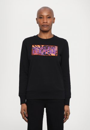Svart hettegenser med en dristig, fargerik "Versace Jeans Couture" logo. Mykt stoff, ribbet halskant og mansjetter, med rett falm.
