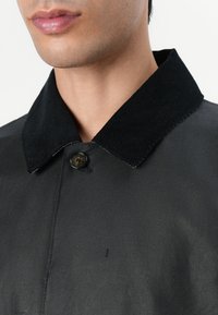 Black collar jacket featuring a corduroy collar and button closure, with a smooth texture and clean lines.