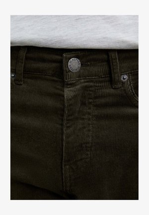 Pantalones de pana verde oscuro con una tela texturada, botones de metal y una marca en la cinturilla. Costuras visibles y bolsillos.