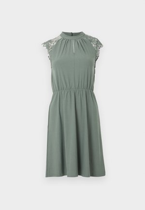 Robe sans manches vert sauge avec des détails en dentelle sur les épaules, col montant, taille froncée et jupe évasée longueur genou.