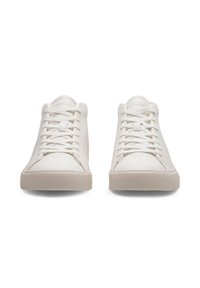 Valged tennisjalatsid, millel on sile nahk pealis, ümar varvas ja tasased kummitaldad. Omab klassikalist paeltega disaini ja tekstuuriga küljeaktsente.