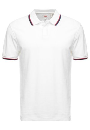 Weißes Polo-Shirt mit kurzen Ärmeln, rotem und marineblauem Besatz am Kragen und an den Ärmelabschlüssen, mit einer Zweischnallenleiste und Levi’s-Label innen im Kragen.