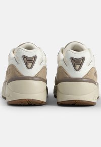 Sneaker bianchi e beige realizzati in suede e pelle, con punta arrotondata, collo imbottito, suola testurizzata e un delicato dettaglio del logo sul tallone.