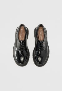 Black patent leather lace-up shoes with brogue detailing, rounded toe, and thick rubber soles. Size 37 shown on insoles.