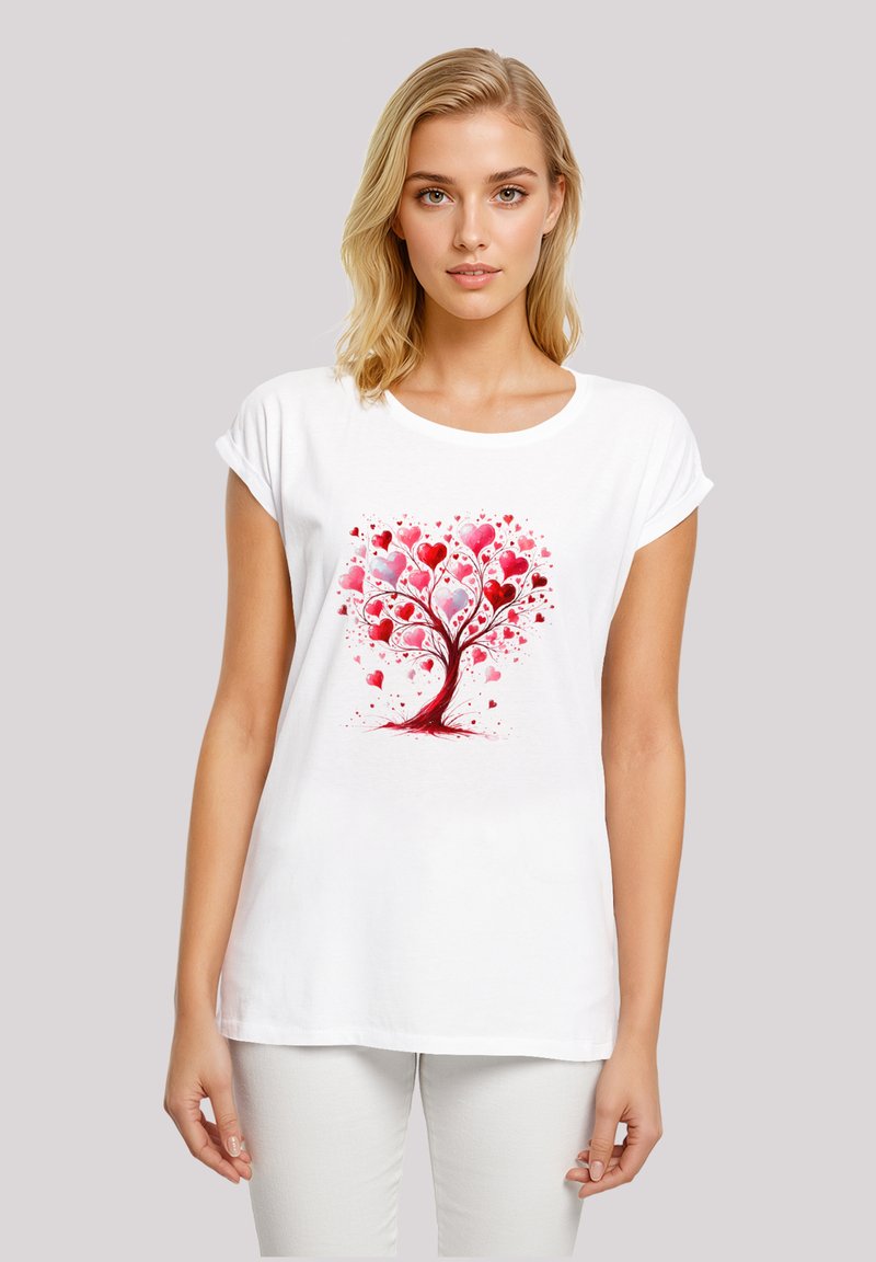 White t-shirt featuring a colorful tree design with red and pink heart shapes, short rolled sleeves, and a relaxed fit.