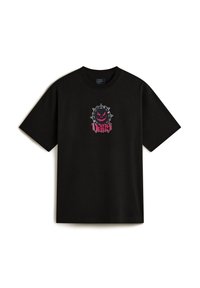La camiseta de algodón negra presenta un gráfico central con un diseño de círculo con picos y una cara sonriente en rosa y negro. Mangas cortas, cuello redondo.