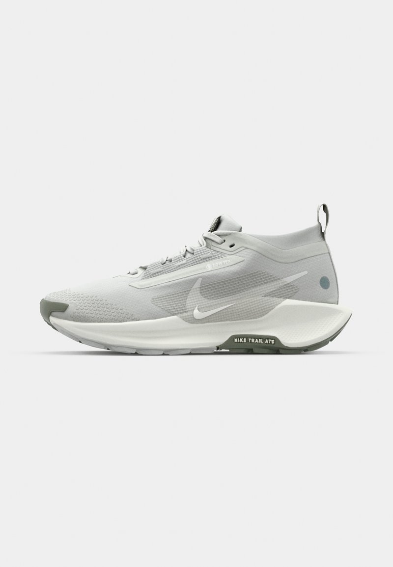 Zapatilla de running gris claro con parte superior de malla texturizada, acentos reflectantes y suela acolchada. Presenta un talón en forma cónica y una lengüeta.