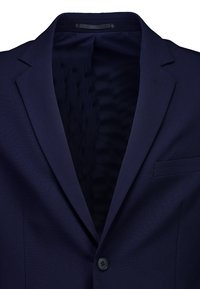 Blazer bleu marine foncé à bouton unique avec revers crantés et poche poitrine passepoilée, montrant une doublure intérieure lisse.