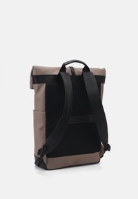 Zaino roll-top in materiali taupe e nero. Presenta un pannello posteriore in rete, spallacci regolabili e tasche laterali per una maggiore utilità.