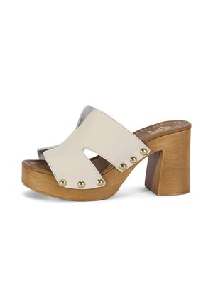 Mule beige en cuir à bout ouvert avec des clous dorés sur une plateforme en bois et un talon haut et épais.