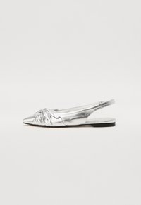 Chaussure plate argentée en métal, à semelle slingback, avec un bout pointu, un détail de nœud texturé à l'avant et une fine semelle noire. Finition lisse, design minimaliste.