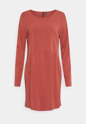 Vestido de mangas longas na cor ferrugem, com decote redondo e costura na cintura franzida, confeccionado em tecido suave com uma textura lisa.