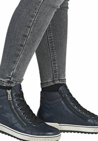 Baskets montantes en cuir bleu marine avec une finition texturée, dotées d'une fermeture éclair sur le côté, de lacets noirs et d'une semelle en caoutchouc blanche.