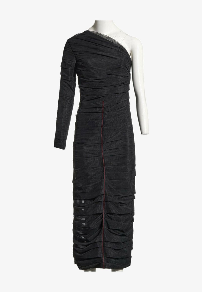 Robe noire asymétrique froncée avec une longue manche gauche et une couture verticale rouge au centre, présentée sur un mannequin blanc.