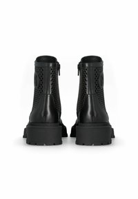 Black ankle boots with a mix of smooth leather and perforated design. Features a patterned sole and side zipper closure for easy wear.