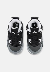 Sneaker nere e grigie con tomaia in rete, collo imbottito e design con lacci. Accenti bianchi notevoli e logo visibile sulla linguetta.