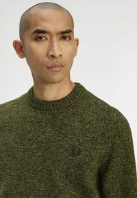 Maglione verde mélange in maglia con scollo a girocollo a coste e dettaglio del logo sottile sul petto sinistro. Texture morbida e vestibilità casual.