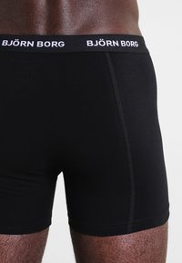 Fekete pamut boxer alsó, fehér "BJÖRN BORG" logóval a derékpánton. Szoros szabású és puha, sima textúrájú.