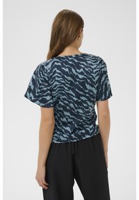 Tričko s krátkým rukávem s modrým a světle modrým abstraktním vzorem, vyrobené z hladké tkaniny, s uvolněným střihem a kulatým výstřihem.