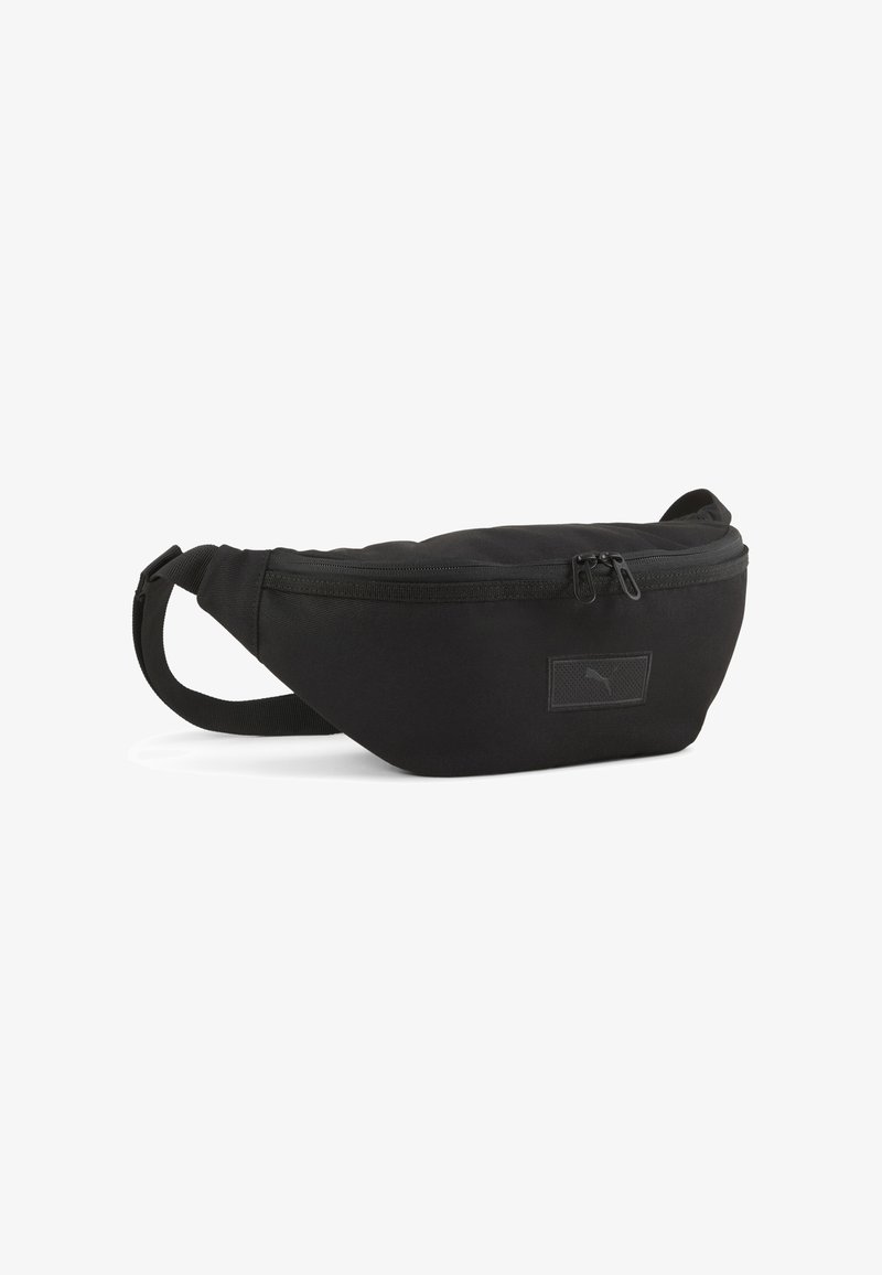 Zwarte stoffen heupriem met een gebogen vorm, ritsafsluiting, verstelbare band en een klein merklabel op de voorkant.