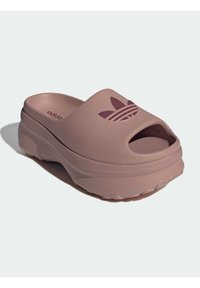 Roze rubberen slippert met open teen, voorzien van een verhoogd logo en een gestructureerd oppervlak, ontworpen voor comfort met een dikke zool.