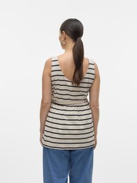 Bézs és fekete csíkos ujjatlan felső széles hátkivágással, derékban húzott és laza szabású. Laza fazonú kék farmernadrággal párosítva.