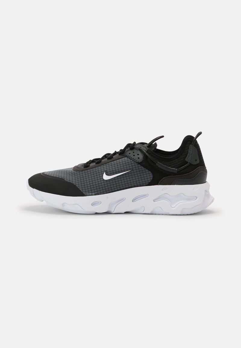 Fekete és szürke sportcipő, textúrált hálós felsőrésszel, rácsos mintával, fehér Nike logóval és vastag, párnázott talppal.