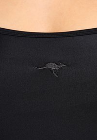 Schwarzes Tanktop aus glattem, elastischem Stoff; mit einem kleinen, bestickten Känguru-Logo auf der Vorderseite.