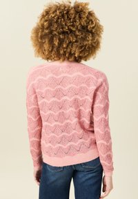 Hellrosa Pullover mit Zickzackmuster, aus einem strukturierten Strickstoff gefertigt. Verfügt über eine lässige Passform sowie gerippte Bündchen und Saum.