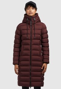 Manteau long matelassé bordeaux avec un col haut, une capuche à cordon, une fermeture éclair pleine longueur et des poches latérales. Texture lisse et silhouette ajustée.