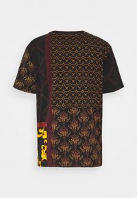 Black short-sleeve shirt with mixed patterns in gold and maroon, featuring geometric and floral designs, and two vertical accent panels.