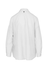 Cammicia bianca a maniche lunghe con colletto, vestibilità rilassata, dettaglio con apertura sul retro e polsini con bottoni. Realizzata in un tessuto leggero.