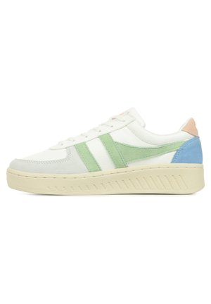 White sneaker with green suede and leather accents, round toe, textured sole, and a pastel blue and pink heel detail.