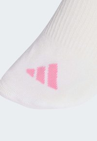 Calzino bianco con texture a coste e logo rosa composto da tre forme triangolari, posizionato nell'area della punta. Tessuto morbido.