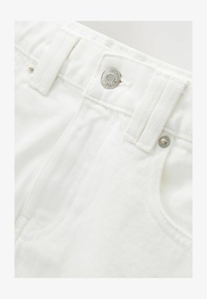 Pantalones cortos de mezclilla blanca con una pretina estructurada, detalle de botón plateado y tejido texturizado. Presenta bolsillos frontales y costuras cuidadas.
